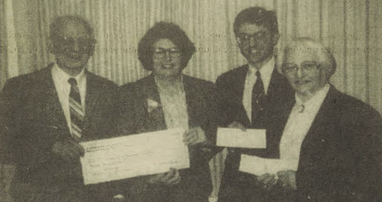 vintage newspaper photograph of people holding a large check establishing the Baeumler-Kaplan Holocaust Memorial Lecture Series at UMD.